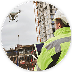 man in white hard hat supervising a drone survey